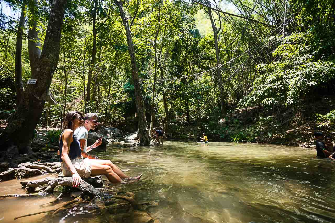 Travelers and locals are having fun in a natural pool Sai Yok Waterfall.