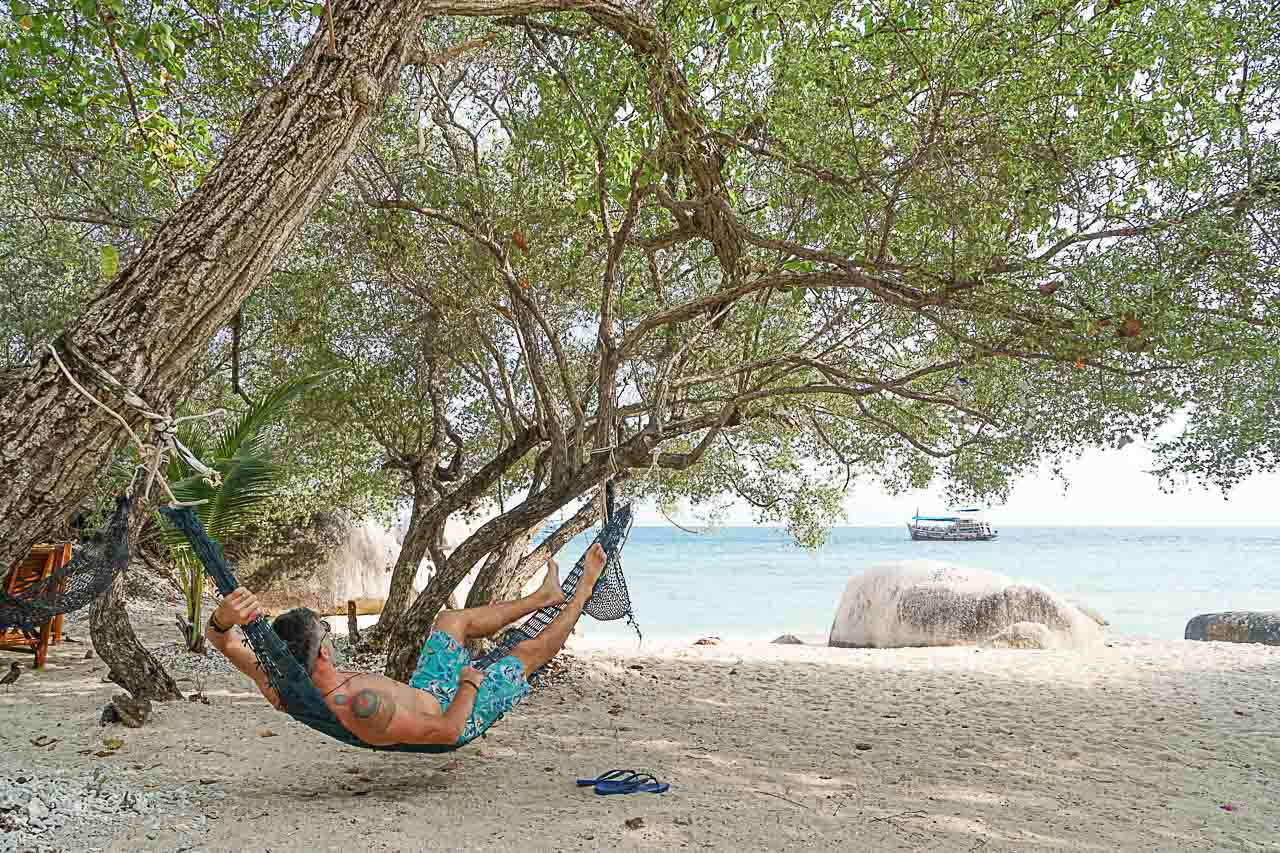 Man in a hammock at a beach on Koh Tao, Thailand.