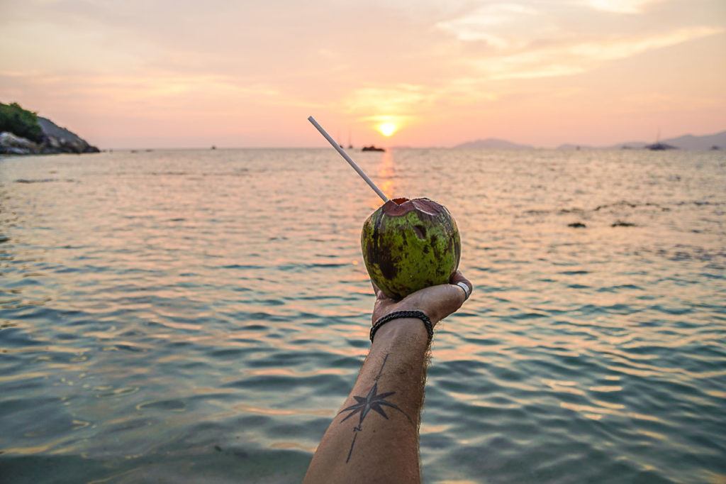 Coconut being held upon the sea of Thailand.
